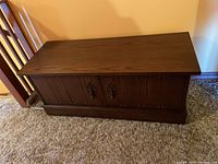 Closed view of the Lane cedar blanket box showing dark stained wood exterior and decorative metal handles and hinges.