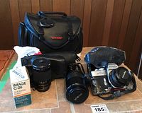 Full set including Minolta SR-T 201 camera with attached lens, additional lenses, Image C-26 flash in box, and Sharp branded black carrying case on tile floor.