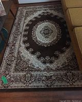 Full view of woven Georgia Kirman carpet showing overall pattern and color in brown, cream, burgundy.