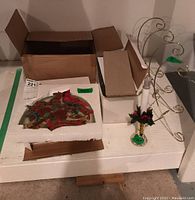 Photo showing wall hanger in original styrofoam packaging and the four metal display hangers with swirl design, plus an LED candle