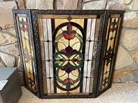 Front view of three-panel stained glass fireplace screen with central panel and two side panels