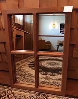 Front view of wood framed mirror with four individual mirror panels divided by frame muntins.
