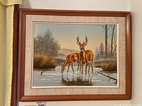 Full view of the framed canvas print showing two deer in a natural setting with trees and water.