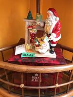 Front angle view of Santa figurine with gifts and fireplace mantel, placed on original Royal Albert box with measurement sticker.