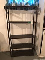 Front view of the black metal shelf unit with five metal shelves, showing overall structure.
