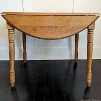 Front view of the maple drop leaf table with one drop leaf down.