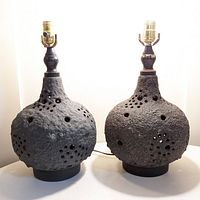 Front view of the pair of Chavignac style lamps showing bulbous textured bases with pierced holes and metal sockets