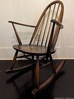 Side view showing curved arms, saddle seat, rocker base and overall profile