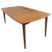 Rectangular teak dining table with tapered square legs, shown angled to capture table surface and leg details.