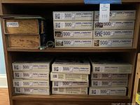 Multiple stacks of 500 piece Bits & Pieces puzzles showing side box details labeled 500 pieces each