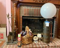 Full view of fireplace items lot including lamp, hearth tools, basket with logs, matches, and dog figurines