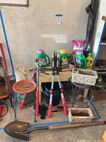 Wide shot of assorted gardening tools and supplies against wall