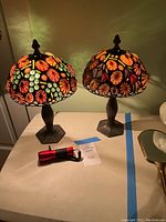 Front view of two lamps lit on table alongside flashlight