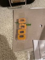 Four yellow rectangular plastic bumper inserts on beige surface