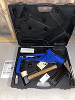 Contents arranged in open molded carrying case on concrete floor