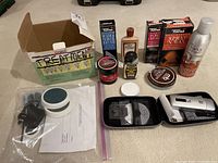 Photo showing all shoe care products along with NONO hair treatment device, charger and instructions.