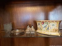 Wide view showing all items on shelf: Spode rectangular bowl with stand, salt and pepper shakers, serving tray, and glass bowls.