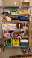 Full view of chrome metal shelving unit loaded with miscellaneous items to show overall structure and size