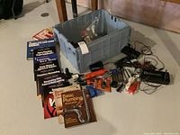 Full lot showing electric screwdrivers, battery charger, assorted drill bits, and home improvement books.
