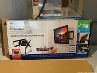 Box of brand new AVer Super Slim TV Wall Mount showing mount arm extending and TV attached to it.