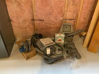 Wide angle photo of Electrolux vacuum with hose, various attachments, vacuum bags, manual, and wall mount.