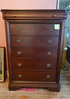 Front view of 6-drawer Vaughan Bassett chest of drawers showing oval brass drawer pulls and decorative molding