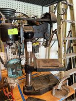 Full view of the Buffalo drill press approximately 38 inches tall showing base, drill head, and handles with visible rust and scratches.