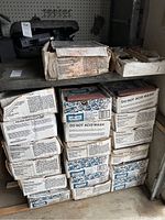 Nineteen stacked boxes of Simons paving bricks with visible labeling, some wear on boxes