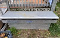 Closed view of the Kobalt aluminum truck storage box showing diamond plate pattern, rust spots, and scratches on surface.