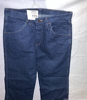 Front view of Rustler blue denim jeans, size 33x30, showing front pockets and waistband and button fly.