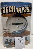 Photo of Catch Phrase electronic game in original clear plastic packaging showing front view of device and packaging text.