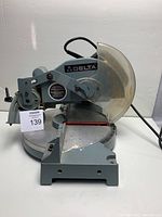 Front view of Delta compound miter saw, showing body, clear blade guard and base with angle marks
