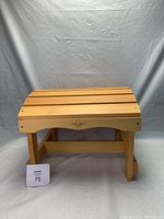 Wooden footrest foot stool with Country Comfort logo visible on front, showing overall shape and design.
