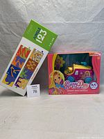 Sunny Day remote control car and Jungle 123 puzzle box in original packaging on white cloth background