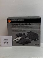 Front and side views of the Black & Decker Deluxe Router Guide box with item pictured on front and details printed on the box.