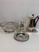 Overview of all silver pieces including coffee server, creamer, silver basket, dish, and platter