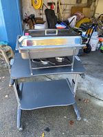 Chafing dish on cart showing front and top cover with handle.