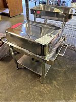 Photo showing one chafing dish with lid on stand, polished stainless steel.