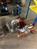 Floor sander on floor showing wooden handles, motor, and metal base with dust port