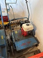 Overall view of Bluebird lawn seeder showing steel frame, seed box, engine and handle