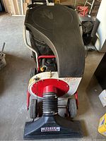 Front view of entire leaf vacuum showing hopper cover, frame, wheels and intake nozzle