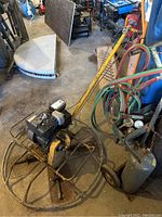 Overview of entire concrete power trowel on concrete floor with surrounding equipment