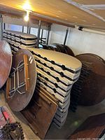 Stack of folded round white tables with legs visible