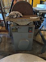 Front view of Rockwell Delta table disc sander showing cast iron base, work table, abrasive disc and power switch.