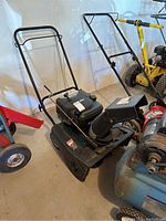 Photo showing overall snow blower with black metal frame, handle, chute, and motor