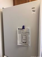 Exterior front view showing white door and attached user manual