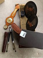 Overview of lot items including barometer, wicker basket, metal plates, tripod, cases, and boxes.