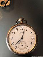 Close-up of Waltham pocket watch showing cracked white dial and black numbers with small seconds subdial at 6.