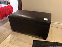 Brown faux leather storage bench closed showing rectangular shape and stitching detail.