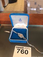 Gruen ladies wristwatch in blue velvet-lined case showing face and part of coil 10k gold band.